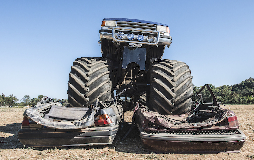 monster truck resting on cars as one of the top 5 5 motorsports events for rain insurance