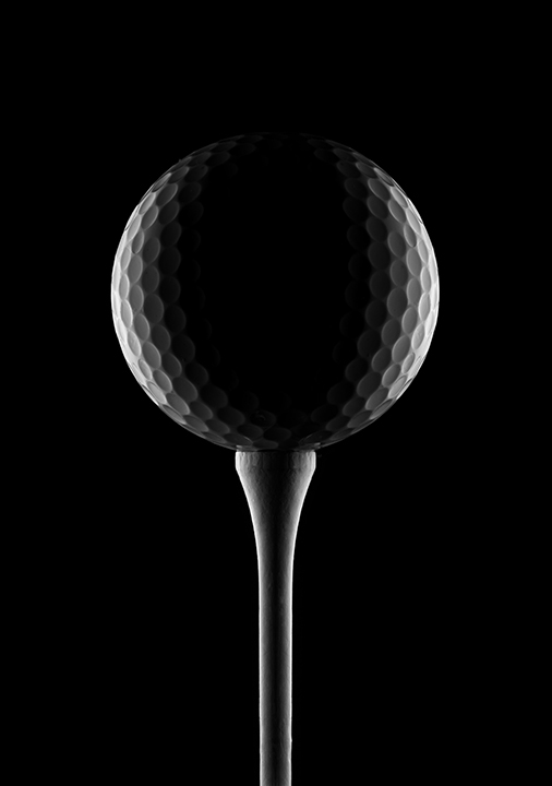 golf ball isolated on black background to represent golf tournament weather insurance