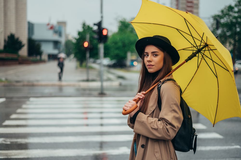 woman-holding-yellow-umbrella-while-in-the-city showing how special event rain insurance helps