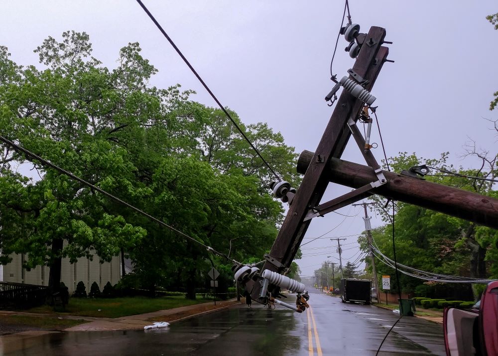 A downed utility pole on a street after a hurricane where hurricane insurance would be useful 