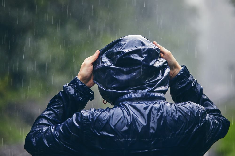 Man in rainsuit after event cancelled wishing he had event risk management