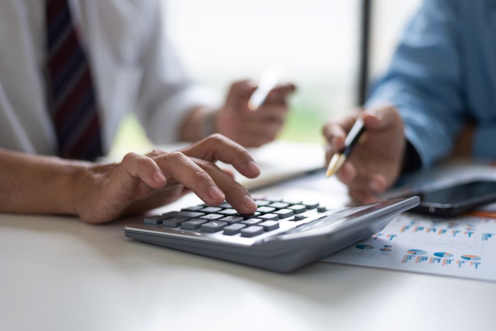 two people suing a calculator to measure costs related to weather data for their event