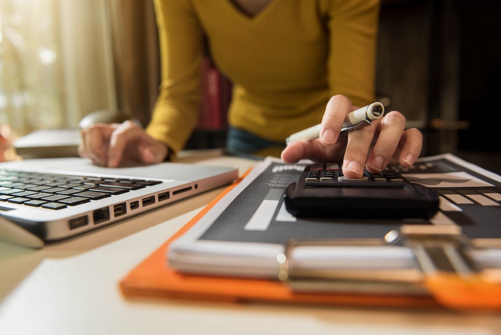 calculator and computer being used to understand rain insurance pricing